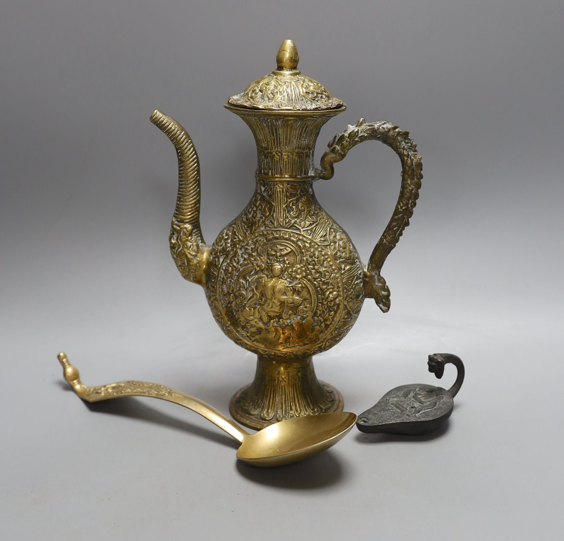 A cast Eastern ewer, 26.5cm tall, together with a miniature cast iron oil lamp and a server spoon (3)